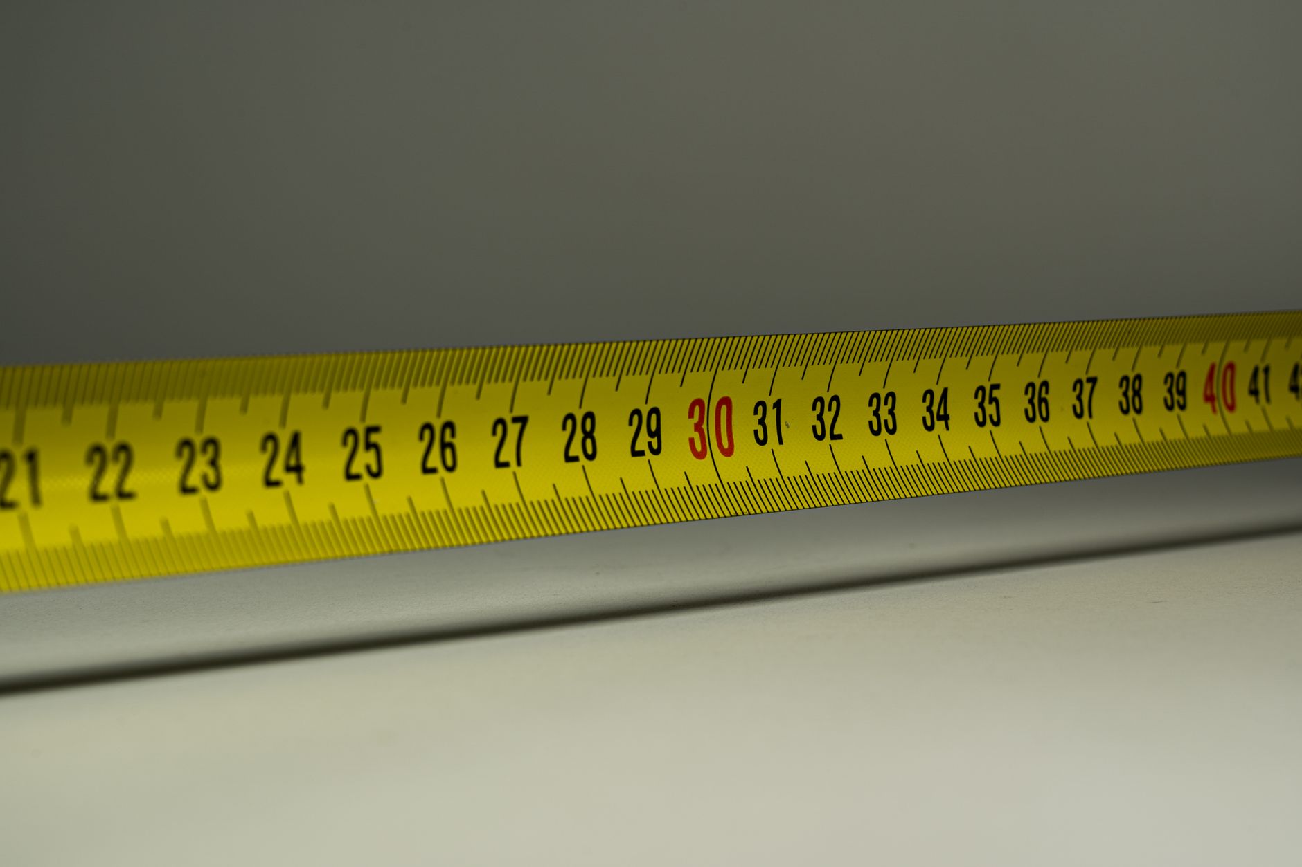 A tape measure on a desk — the packed carton's outside dimensions are what freight is priced on.