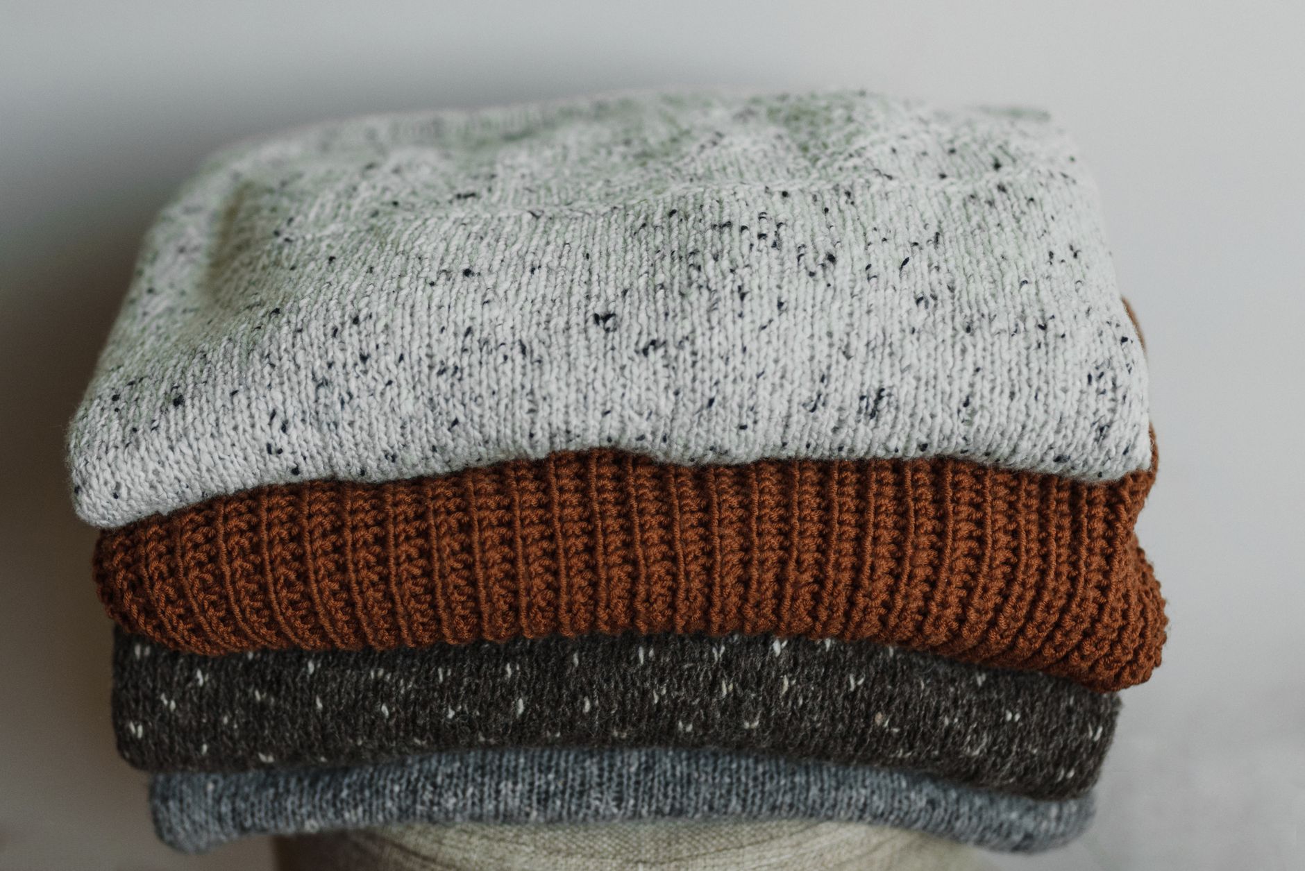 Folded knit pet sweaters and denim pet jackets being packed into cartons